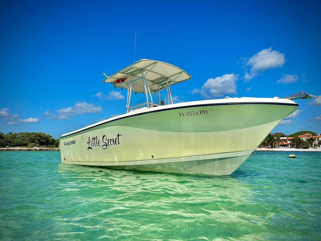 A private boat anchored in clear turquoise waters near Tulum, providing a serene getaway by Carey Tours.
