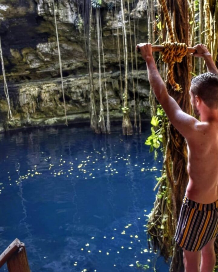 Private tour experience at a serene cenote in Tulum, showcasing a visitor preparing to swim with nature's tranquility by Carey Tours