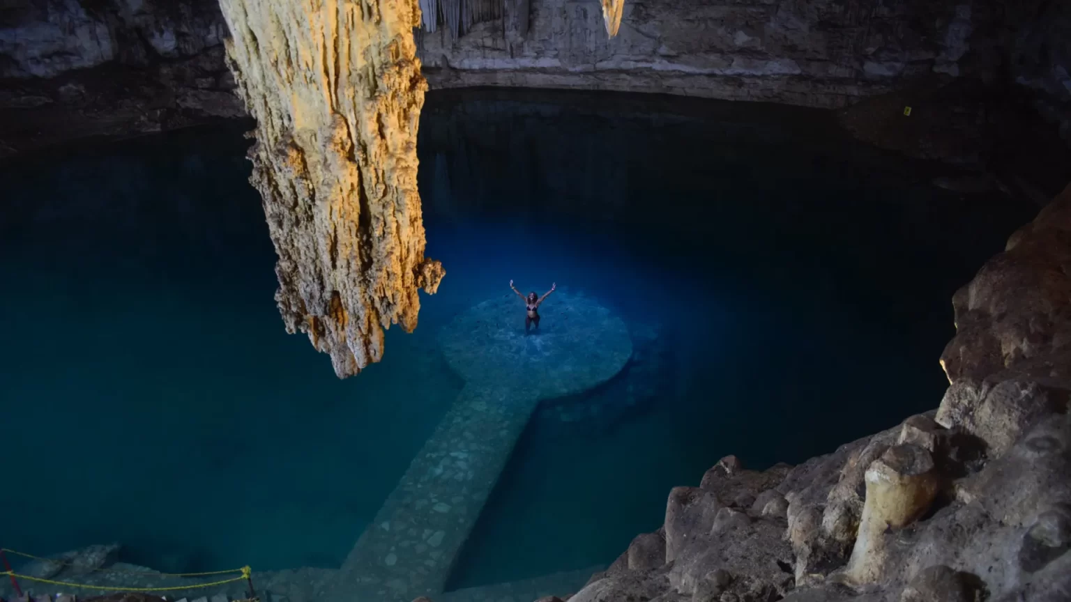 Quiet moment in a turquoise cenote in Tulum, surrounded by natural rock formations, captured during a private tour by Carey Tours.