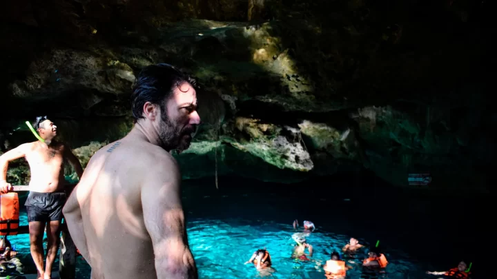 Snorkeling in the serene waters of a cenote surrounded by lush jungle, guided by a local expert from Carey Tours.