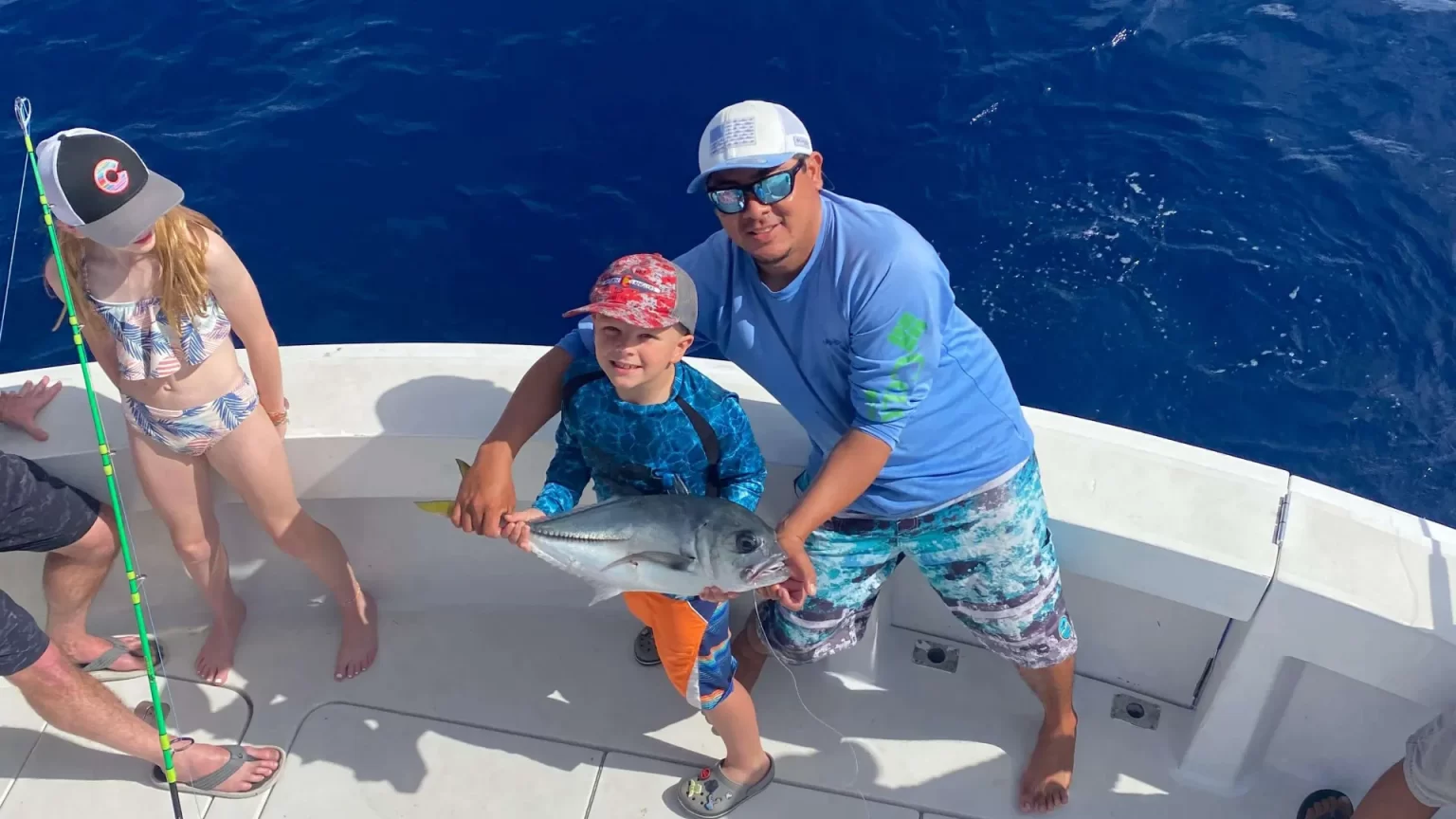 Family-friendly fishing experience in the Caribbean Sea, celebrating a catch with a local guide by Carey Tours.