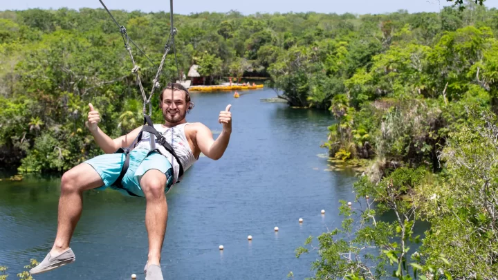 Soaring over a lush jungle landscape on a zip line adventure in Playa del Carmen, guided by local experts by Carey Tours.