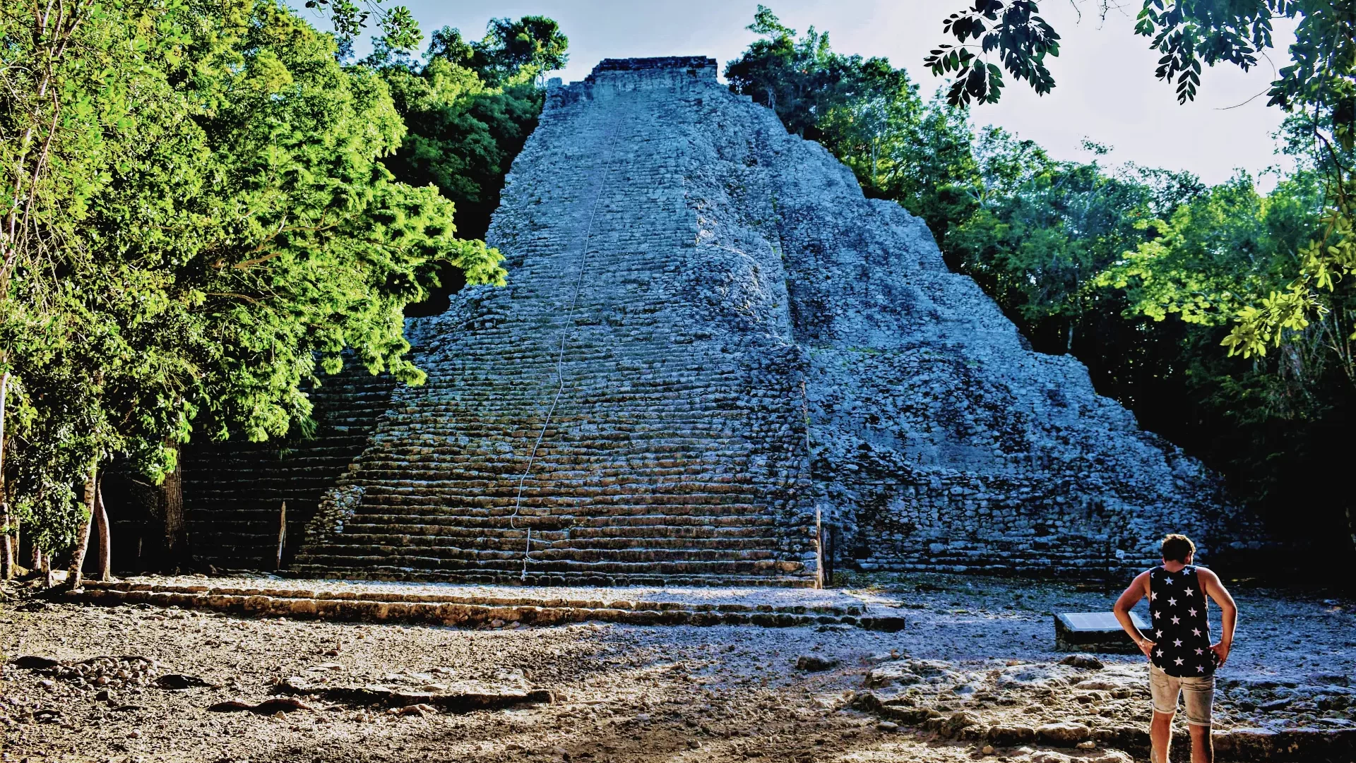 Exploring the ancient ruins of a Tulum archaeological site, surrounded by lush vegetation and tranquility, by Carey Tours.